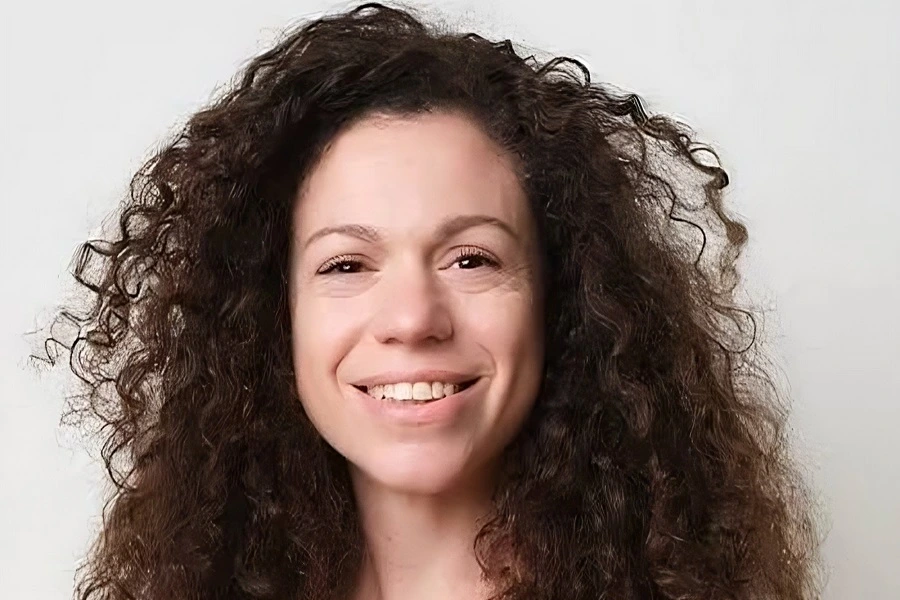 young woman with curly hair smiling